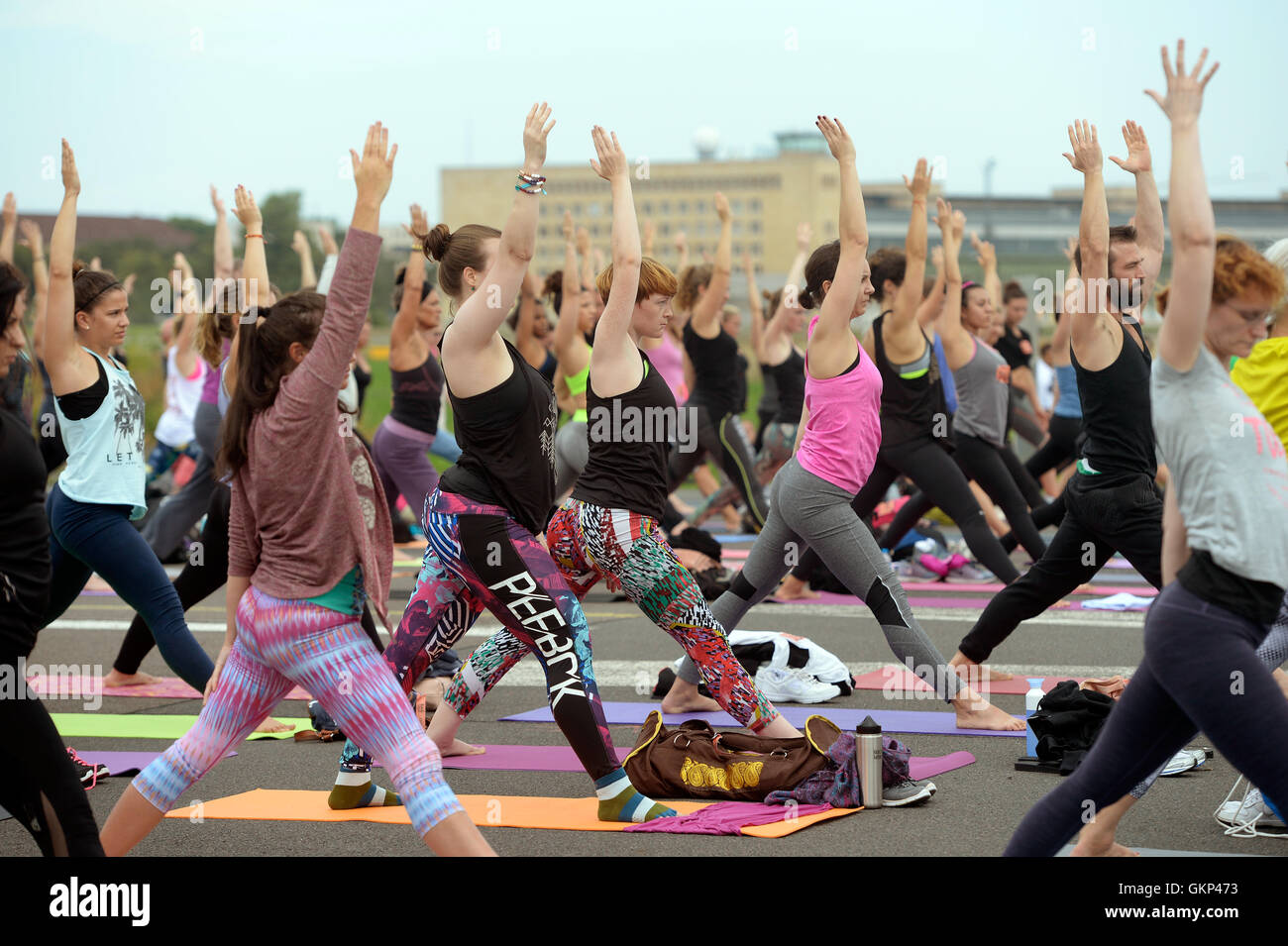 Belin, Deutschland. 21. August 2016. Teilnehmer üben Yoga-Posen auf dem ehemaligen Airfiel Tempelhofer Feld, wie sie in der 'Wanderlust 108' Yoga Event in Belin, Deutschland, 21. August 2016 zu beteiligen. Die Veranstaltung 'Wanderlust 108' wurde als 'eingedenk Triathlon", bestehend aus einer 5-Kilometer-Lauf, einen Yoga-Flow, begleitet von DJ und andere Elemente in den USA gegründet. Die Zahl 108 hat eine besondere Bedeutung in vielen mystischen Traditionen. Foto: Maurizio Gambarini/Dpa/Alamy Live News Stockfoto