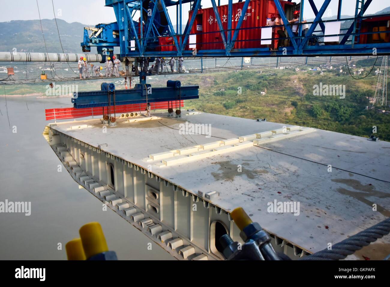 Chongqing, China. 21. August 2016. Arbeitnehmer verbinden der ersten Stahl Kastenträger mit Kabel auf der Baustelle der Fuma Yangtze River Bridge in auch Chongqing, Südwestchina, 21. August 2016. Ein siebenstündige Hebe-Betrieb der erste Stahl Kastenträger der Brücke wurde am Sonntag beendet. Die 2.030 Meter lange Brücke verbindet auch Chongqing und Lichuan Zentral-China Hubei Provinz wird voraussichtlich im Jahr 2017 in Betrieb genommen werden. Bildnachweis: Hu Hua/Xinhua/Alamy Live-Nachrichten Stockfoto