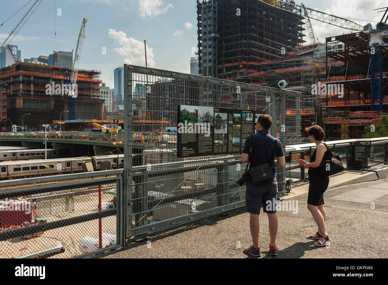 Touristen zu lesen ein Schild mit Informationen über die High Line-Verlängerung in der Nähe von Hudson Yards Entwicklung in New York City. Stockfoto