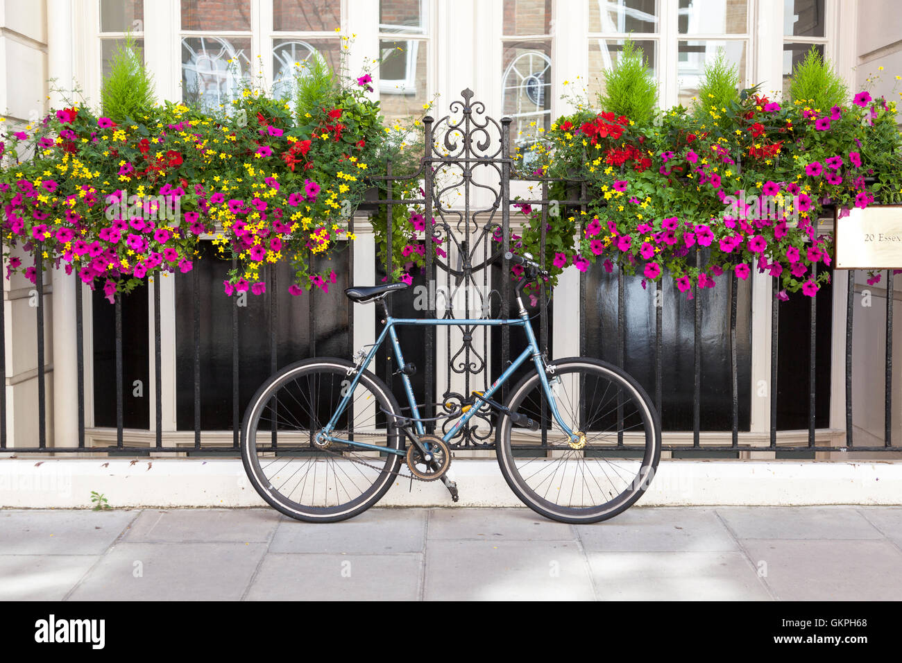 Fahrrad angekettet an ein Geländer vor ein schönes Haus Stockfoto