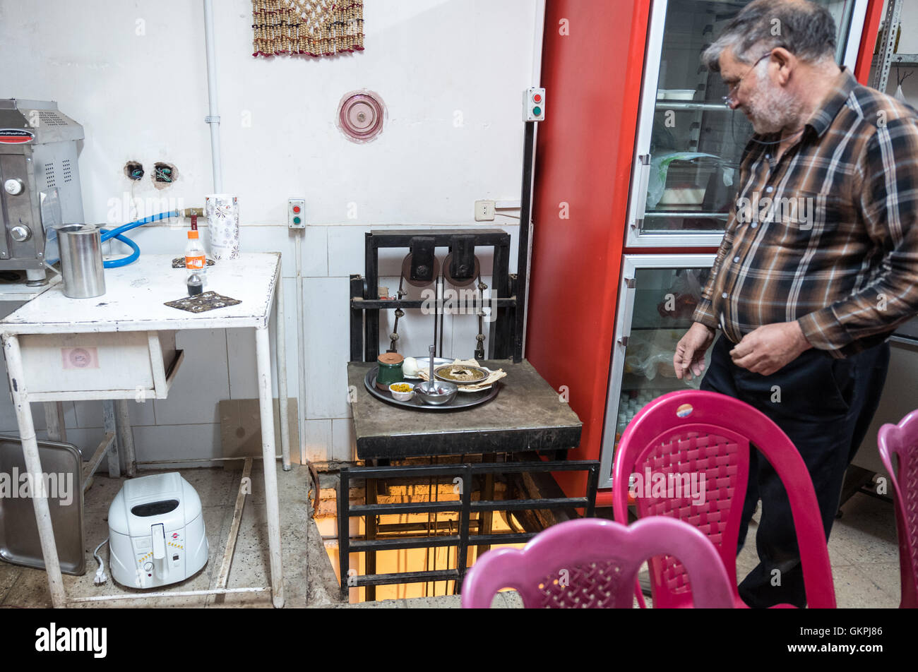 Stumm-Kellner bringt Essen aus der Küche in einem lokalen Abyāneh Restaurant serviert traditionelle iranische Speisen. Stockfoto