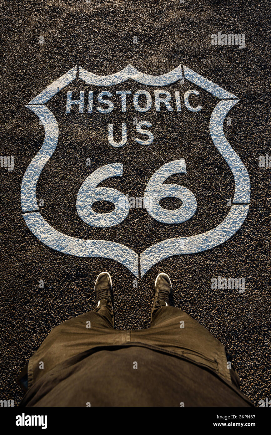 Historische Route 66 Mark auf Asphaltdecke und eine daneben stehende Person. Bild mit hoher Detailgrad. Stockfoto
