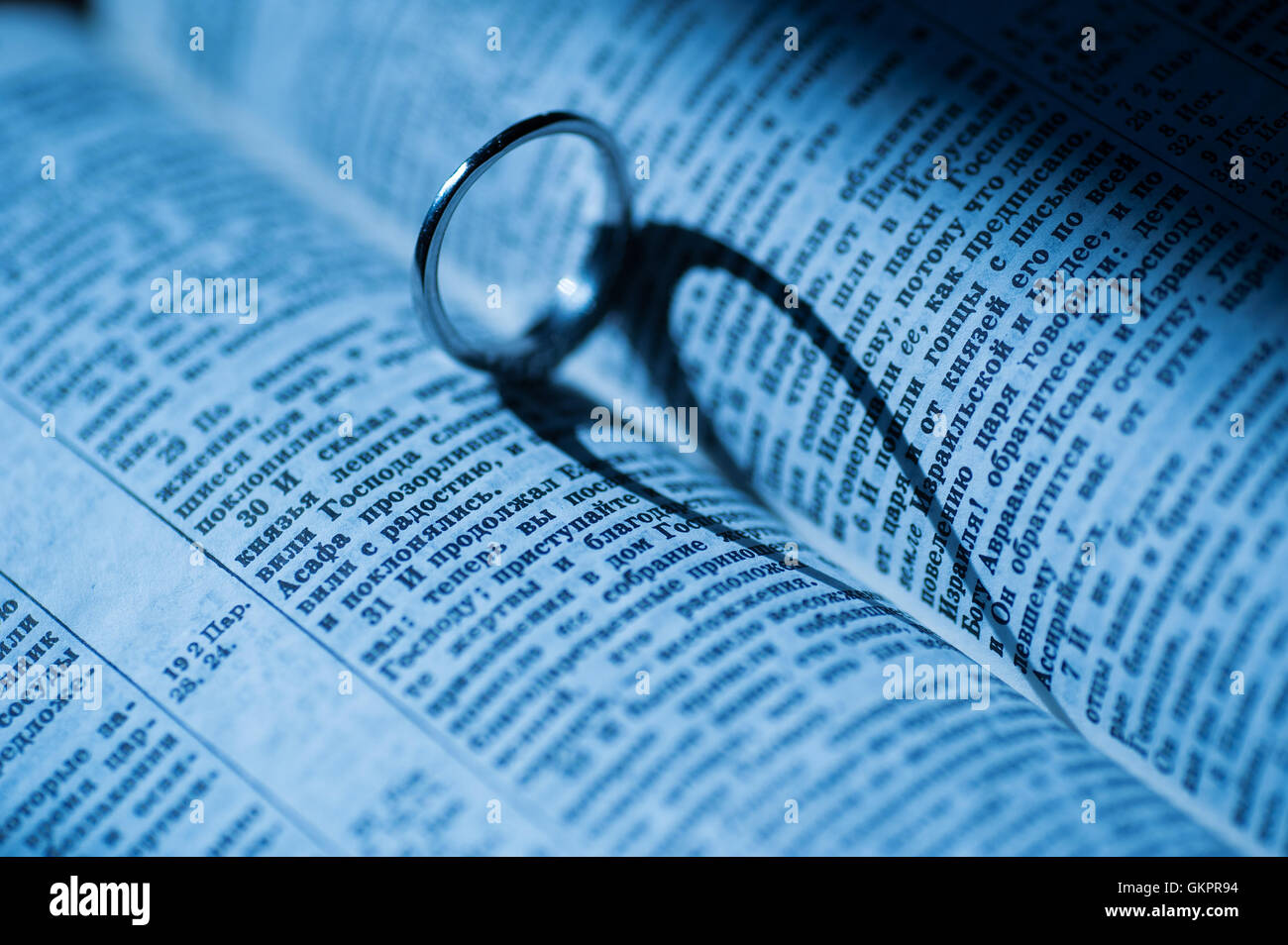 Goldener Ring macht herzförmigen Schatten in Buch Stockfoto
