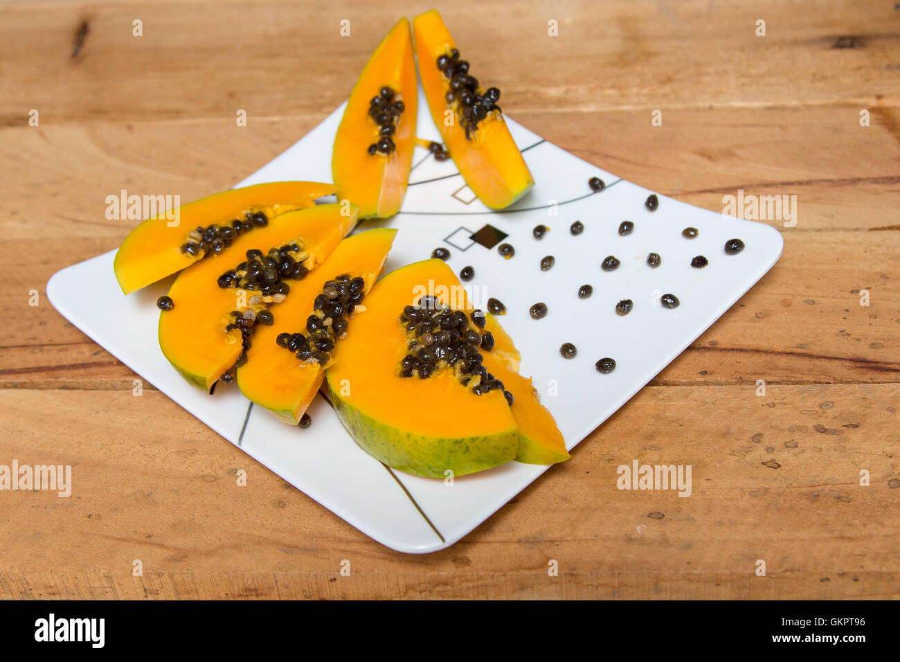 Reife Papaya in Scheiben geschnitten auf weißen Teller Stockfoto