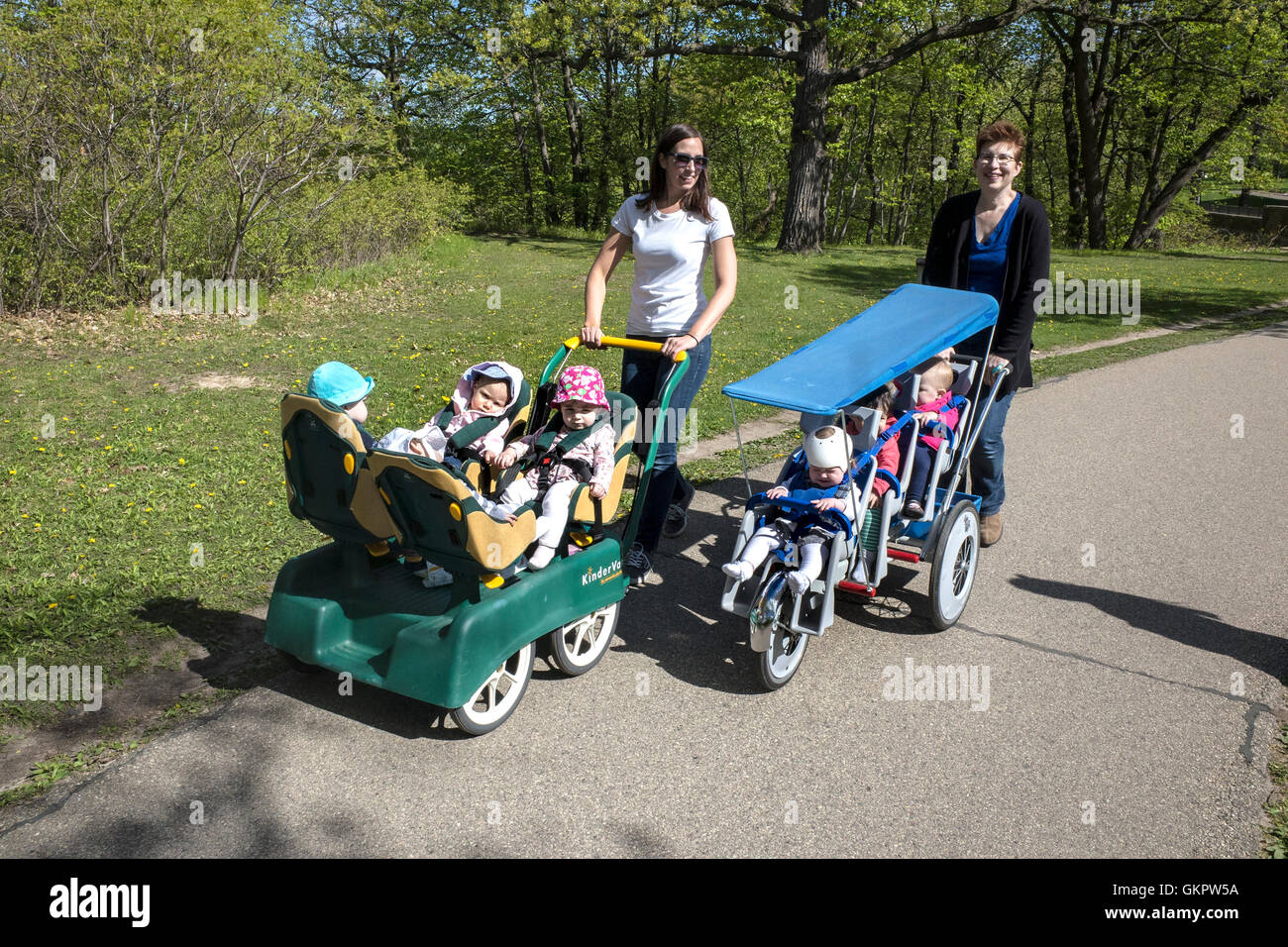 Kindertagesstätte Frau bei einem Spaziergang mit Kleinkindern in Multi fit Kinderwagen. Nord-Mississippi Fluß-Boulevard. St Paul Minnesota MN USA Stockfoto