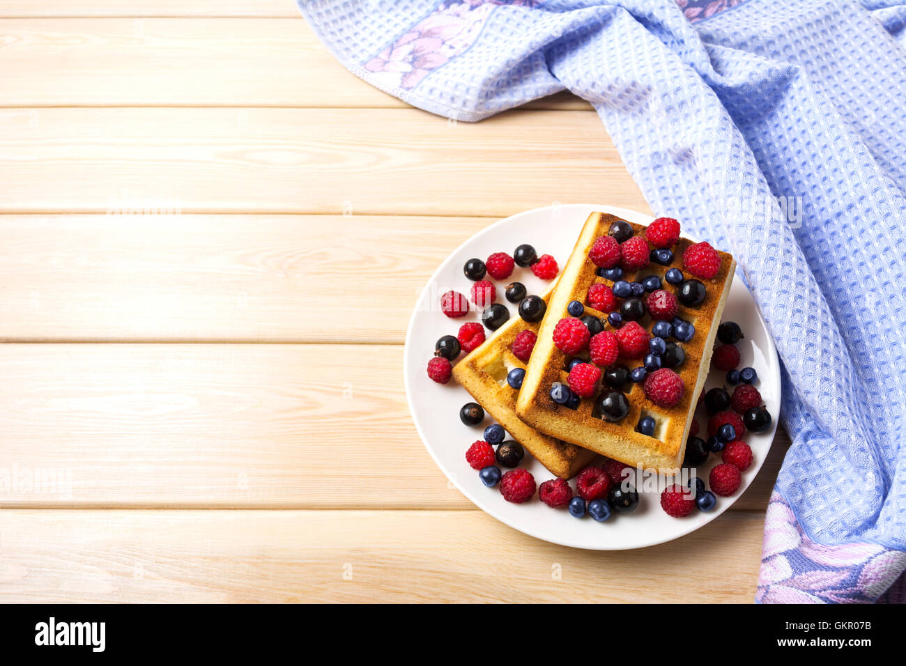 Weiche belgische Waffeln mit Heidelbeeren, Himbeeren und schwarzen Johannisbeeren kopieren Raum. Frühstück Waffeln mit frischen Beeren. Stockfoto