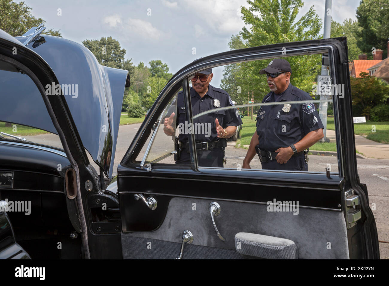 Detroit, Michigan - Nachbarschaft Gruppen halten ein Sommer Street fair. Reserve-Polizisten untersuchen einen 1949 Cadillac auf dem Display. Stockfoto