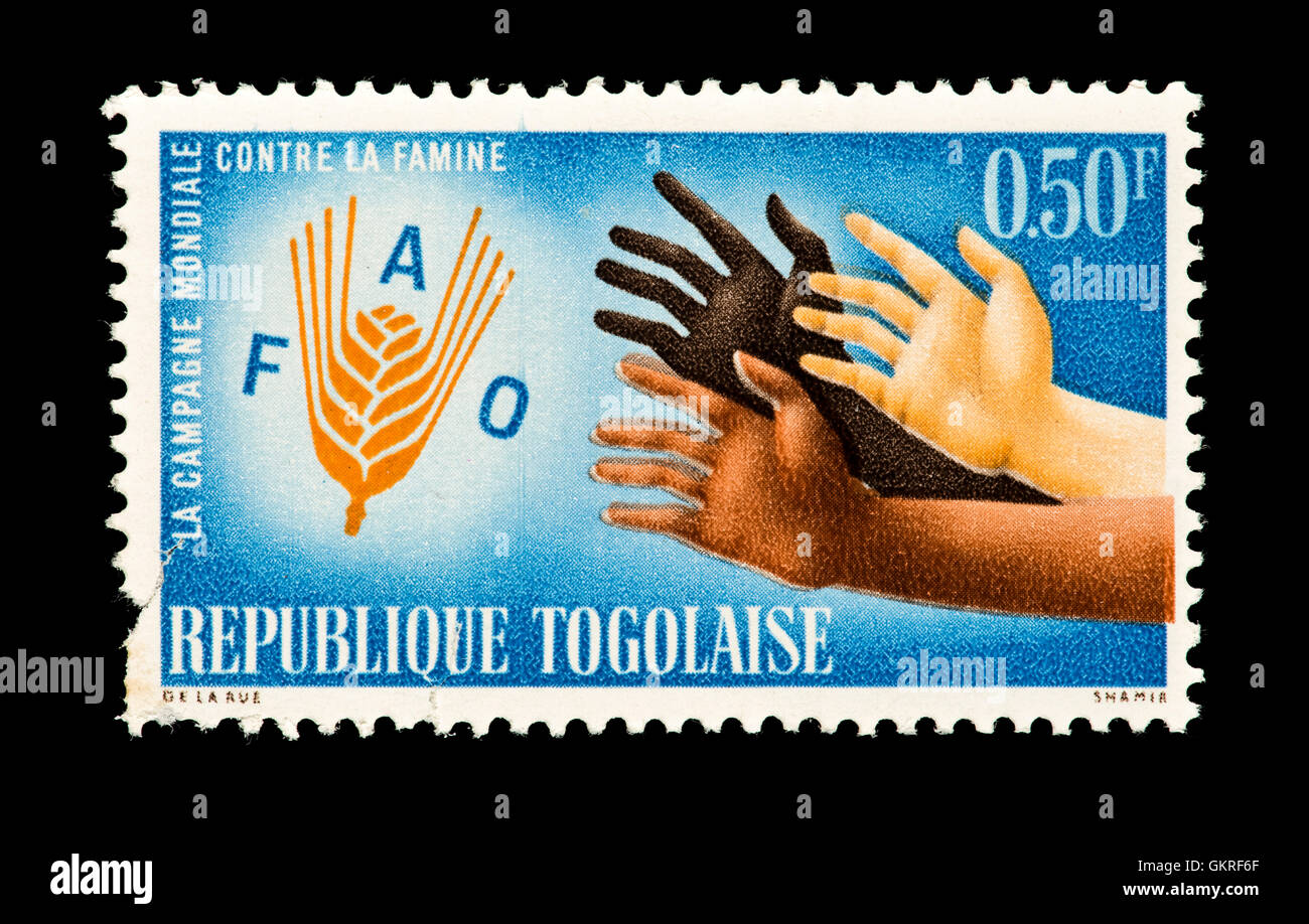 Briefmarke aus Togo, die Hände greifen nach Weizen, Freiheit her Hunger UN-Kampagne darstellen. Stockfoto