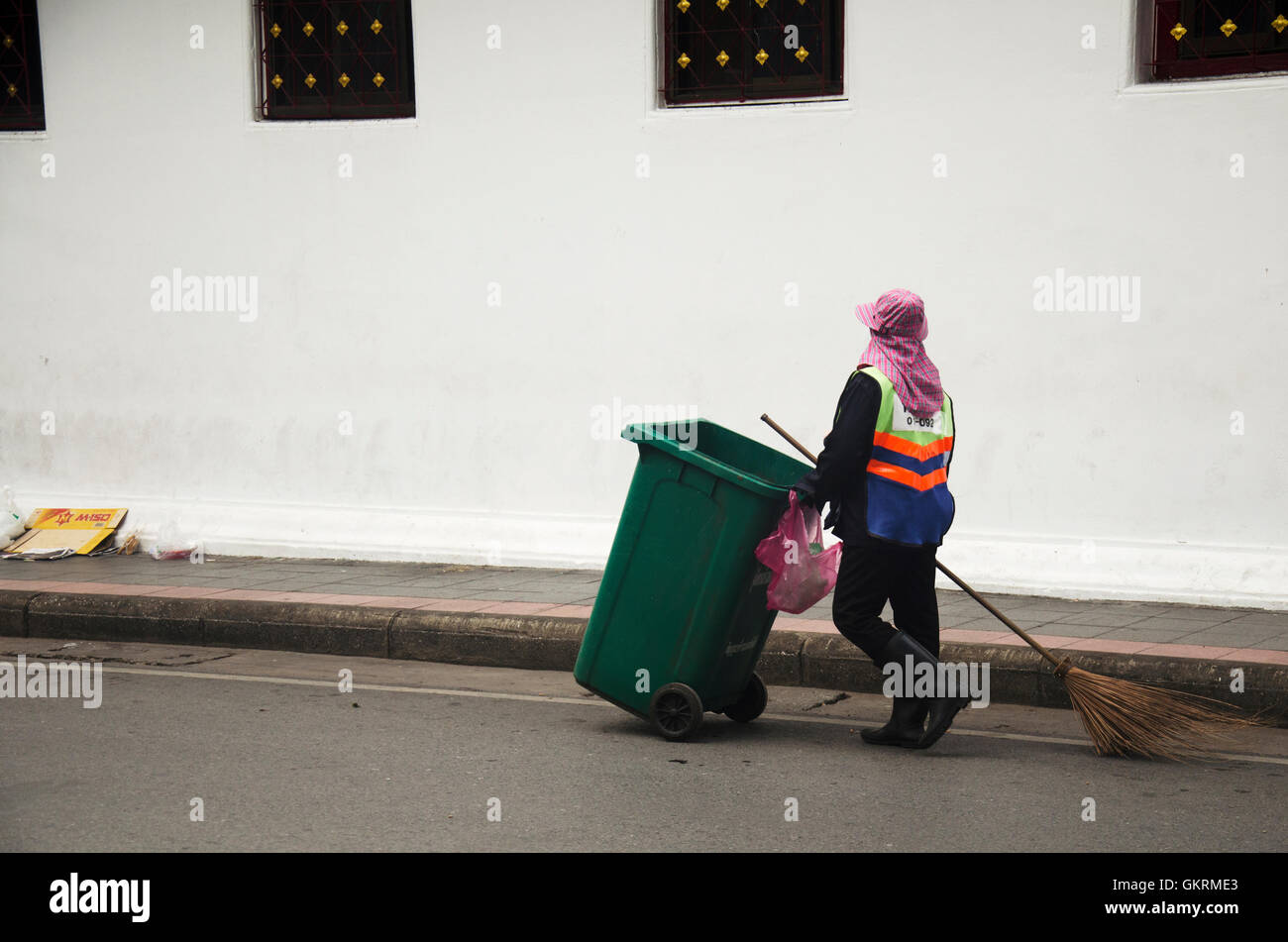 Thai Frau Kehrmaschine Reinigung arbeiten halten Sie Müll und Push Müll Wagen an der Straße am 7. Juli 2016 in Bangkok, Thailand Stockfoto