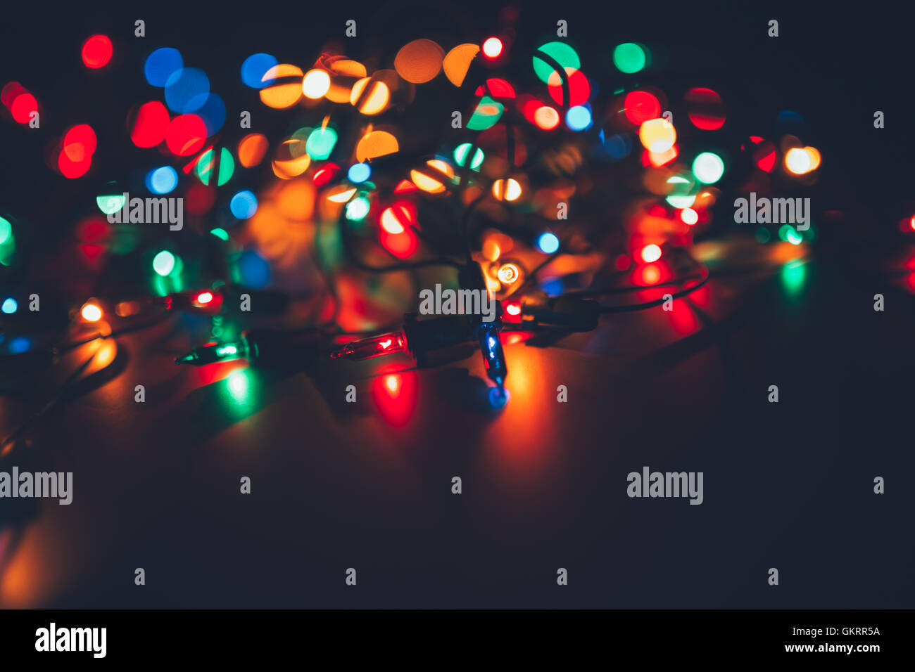 Weihnachtsbeleuchtung auf dunklem Hintergrund. Dekorative Girlande. Getönte Foto Stockfoto