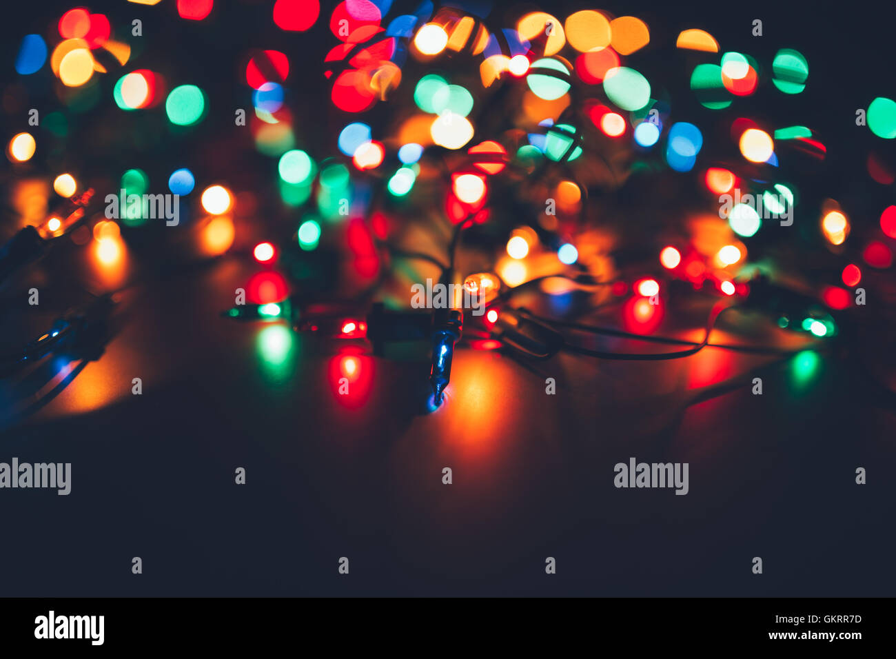 Weihnachtsbeleuchtung auf dunklem Hintergrund. Dekorative Girlande. Getönte Foto Stockfoto