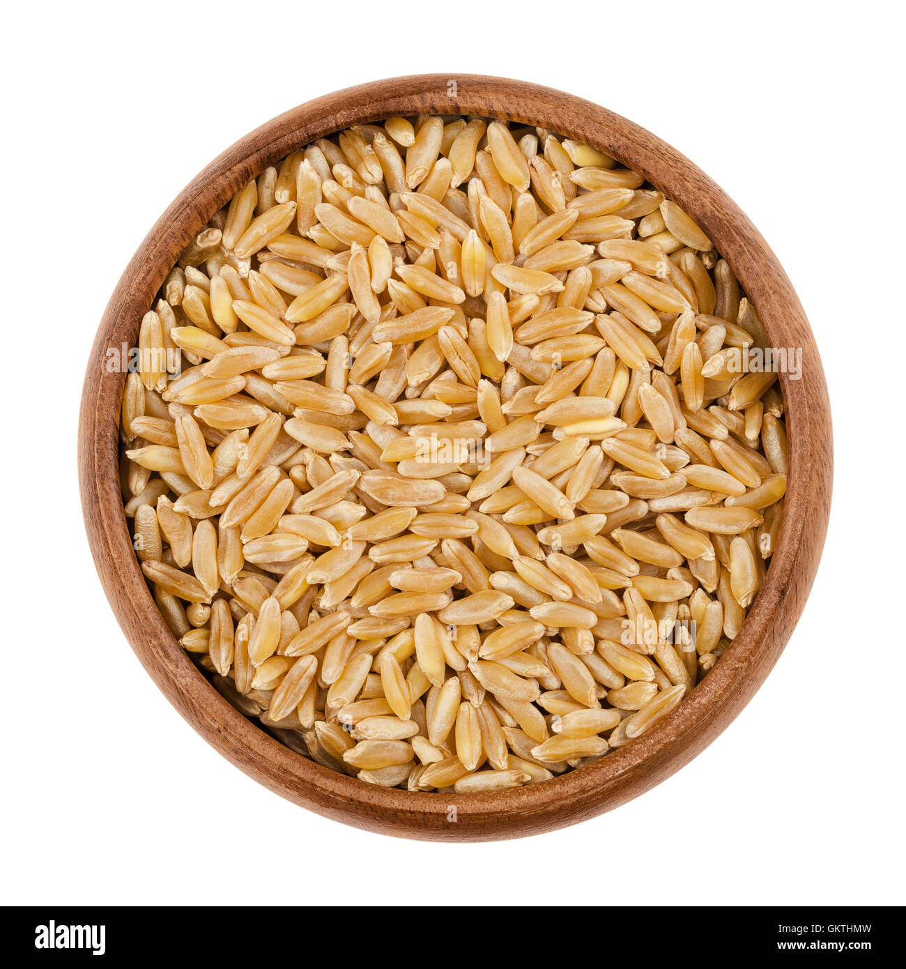 KAMUT Khorasan Weizen in einer Holzschale auf weißem Hintergrund. Weizenkörner, orientalische, Triticum Turanicum. Stockfoto