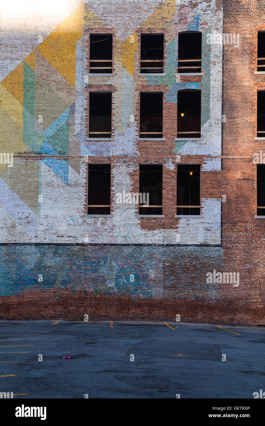Verlassene Gebäude in der Innenstadt von Detroit. Fassade aus Ziegeln, teils mit einem bunten Gemälde gemacht. Zerbrochene Fensterscheiben. Stockfoto