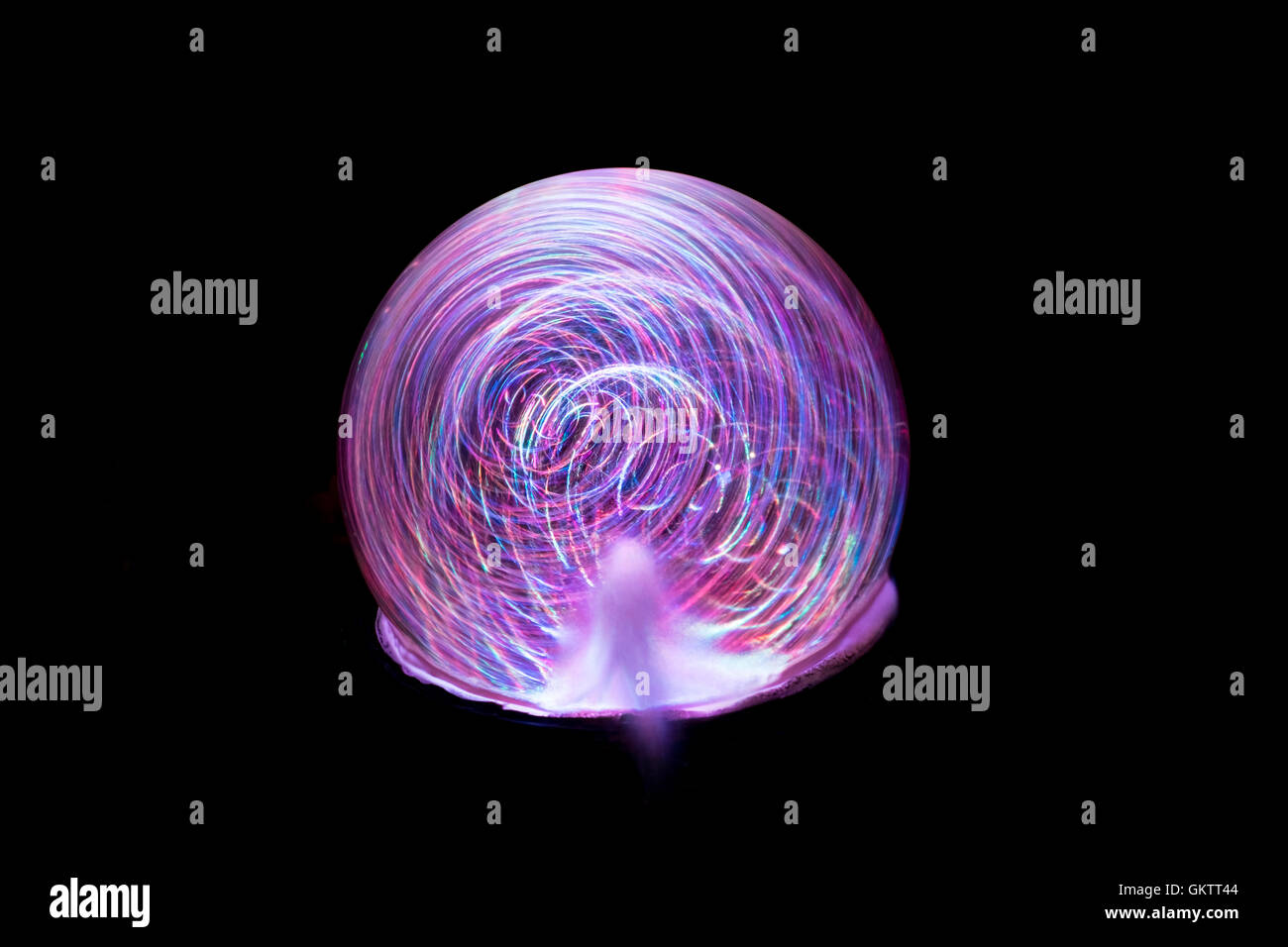 Bewegungsunschärfe von rosa lila und blau Licht als ein Wasserspiel bei Nacht Spins im Langzeitbelichtung eine Planet Wirkung verleihen Stockfoto