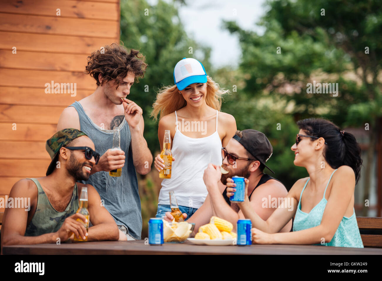 Gruppe von fröhlichen jungen Menschen Essen und trinken im freien Stockfoto