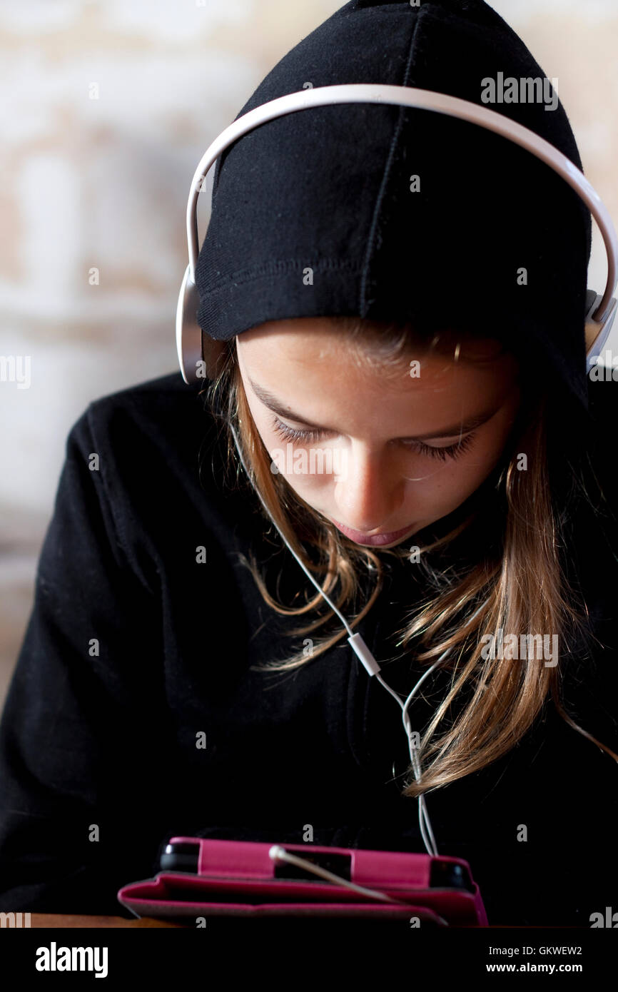 Teengirl mit Hoodie mit Tablet und Kopfhörer Stockfoto