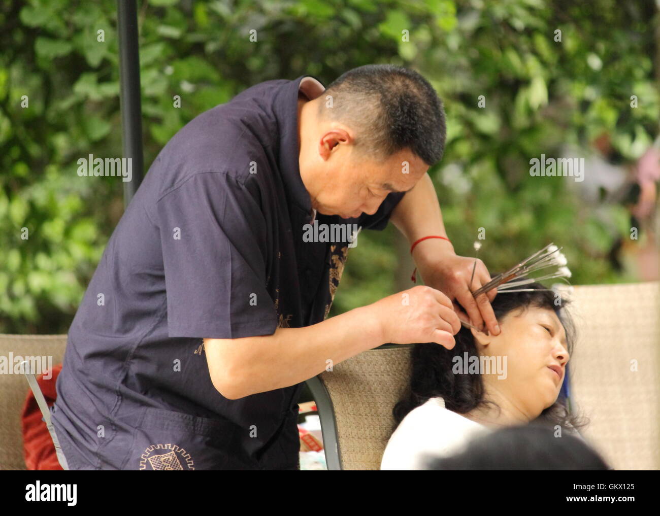 Ein Mann reinigt Ohrenschmalz mit traditionellen Maut im Volkspark in Chengdu China. Stockfoto