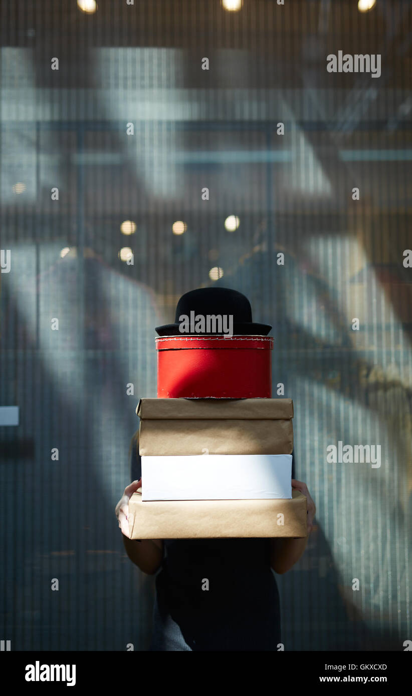 Stapel von Kisten und schwarzen Hut auf der Spitze von Mädchen gehalten Stockfoto