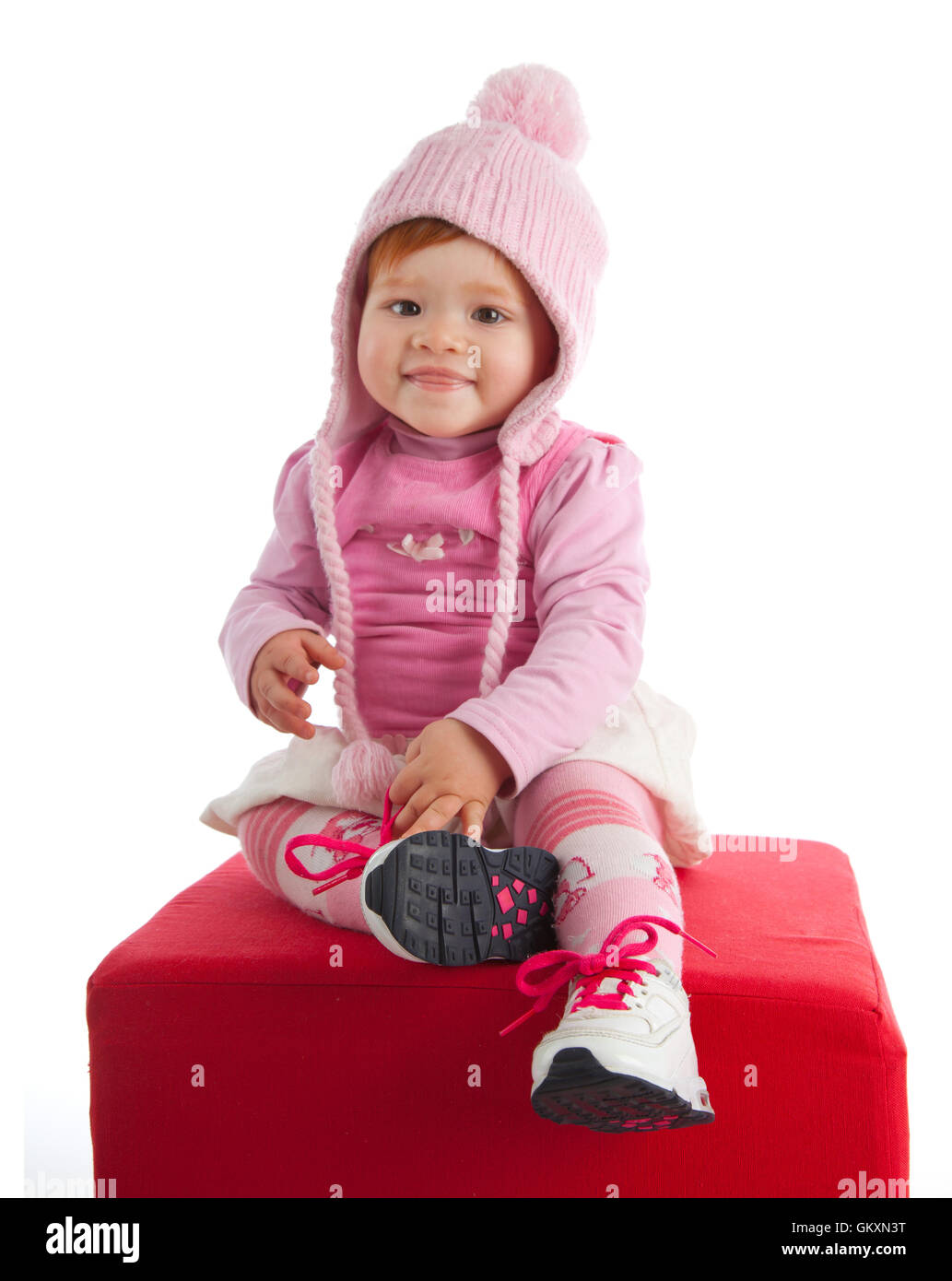 Süß lächelnden Baby mit rosa Wollmütze auf weißem Hintergrund Stockfoto