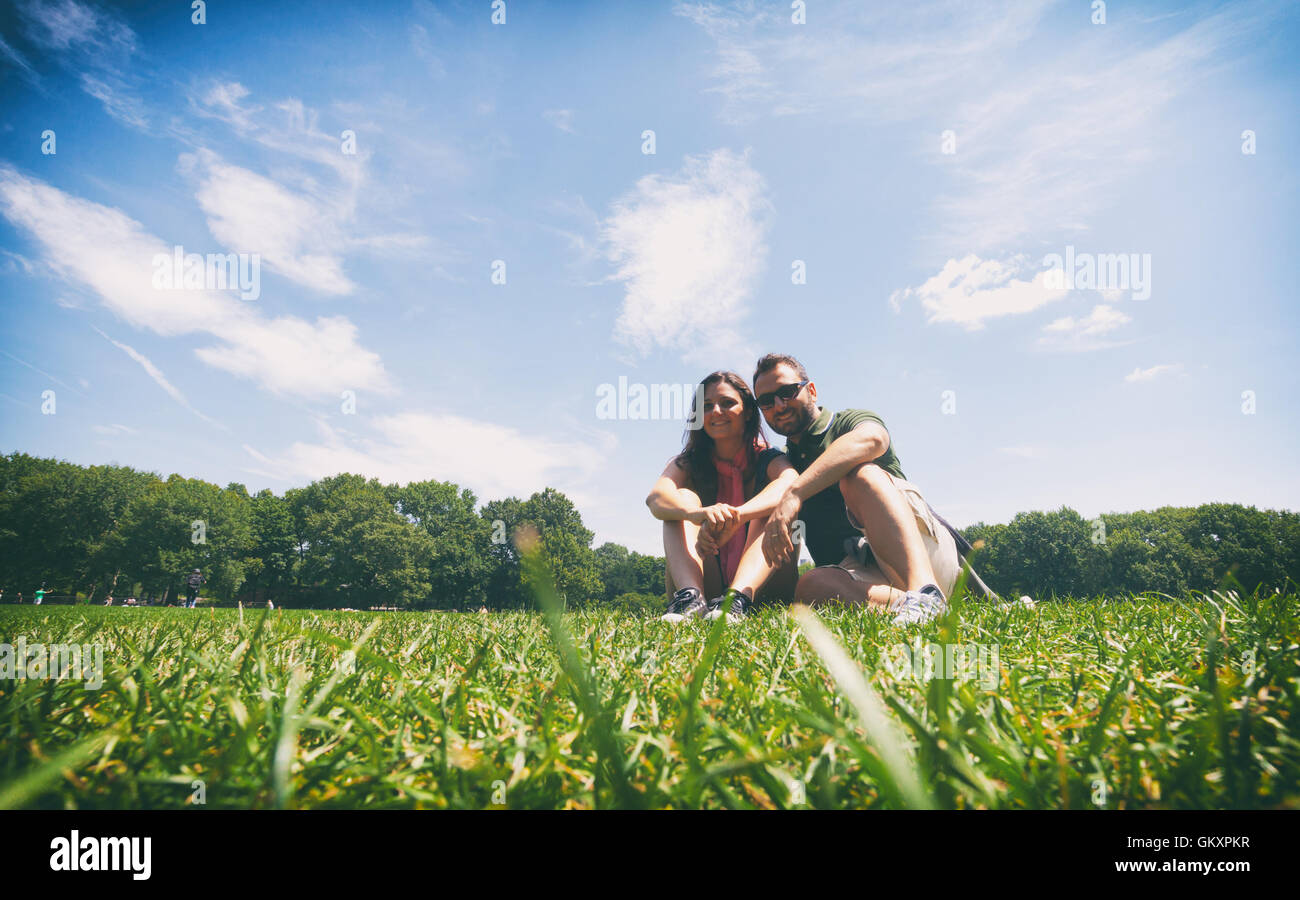 Erinnerungsfoto eines jungen Paares sitzen auf dem Rasen im Central Park in New York City, Vintage-Filter. Stockfoto