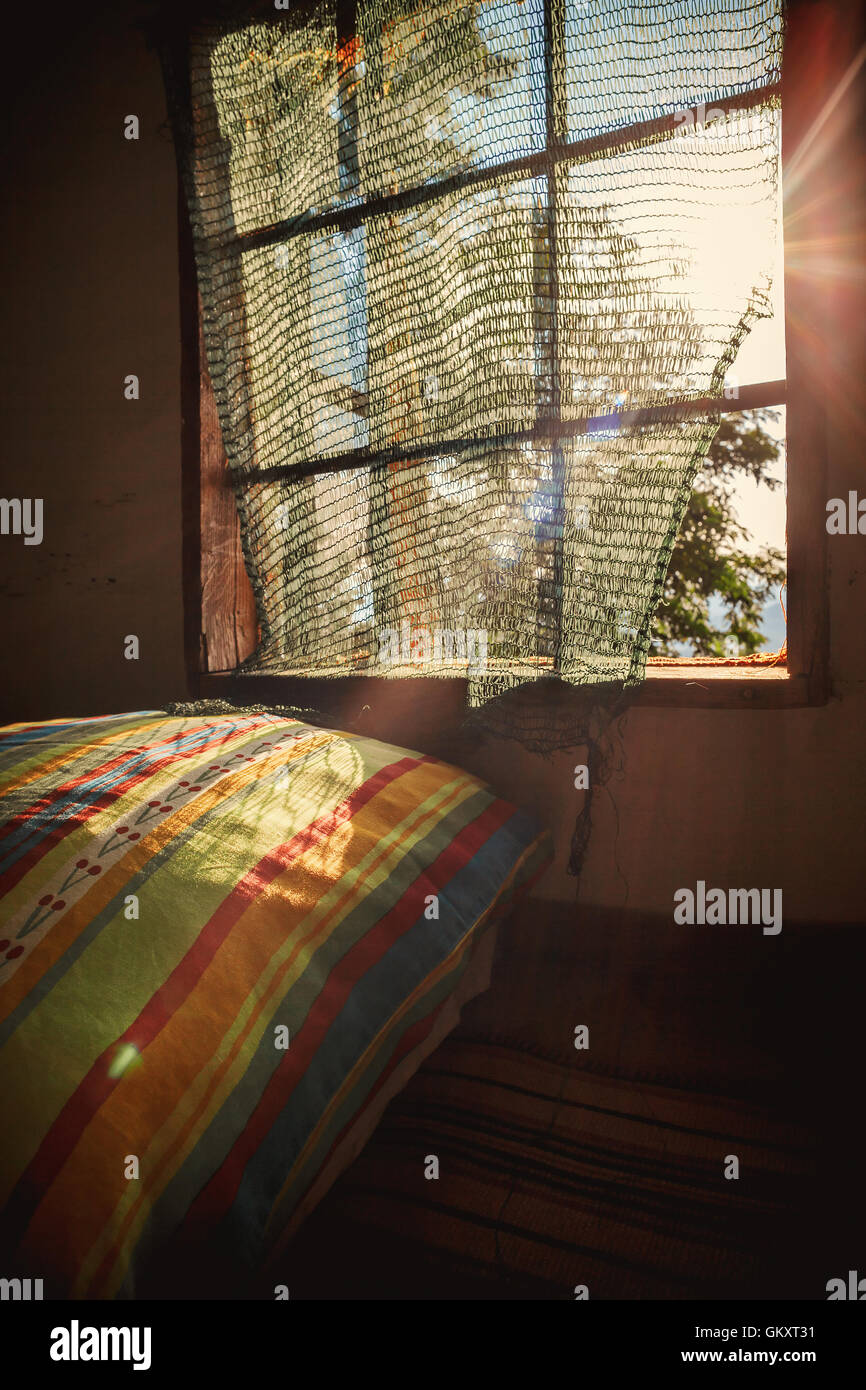 Innenansicht einer alten hölzernen Dachboden Sonnentag, verträumter ambient. Bunte Kissen hinter dem Fenster. Stockfoto
