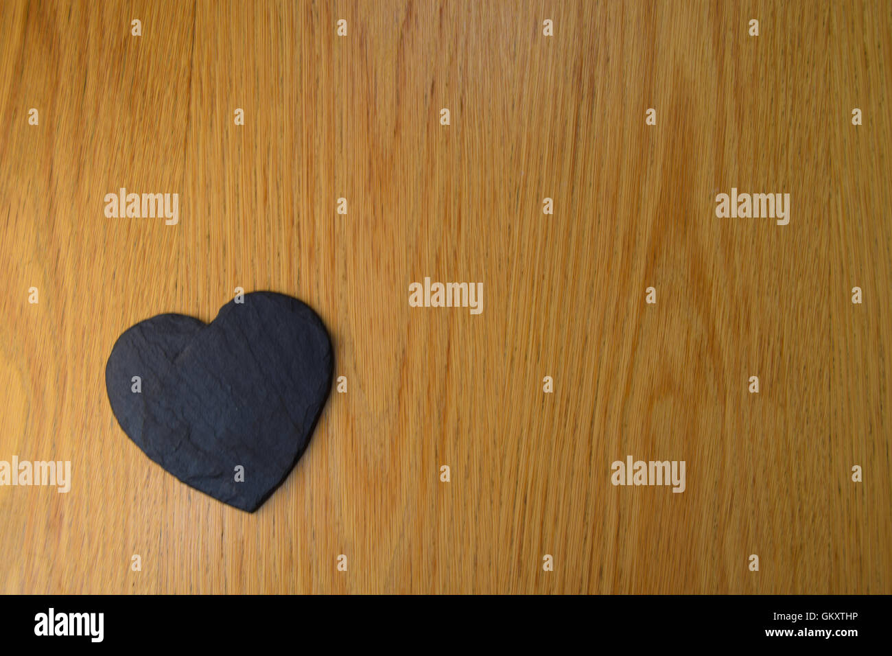 Schiefer schwarz Herz auf Holztisch in der Ecke, Blick in den Himmel Stockfoto
