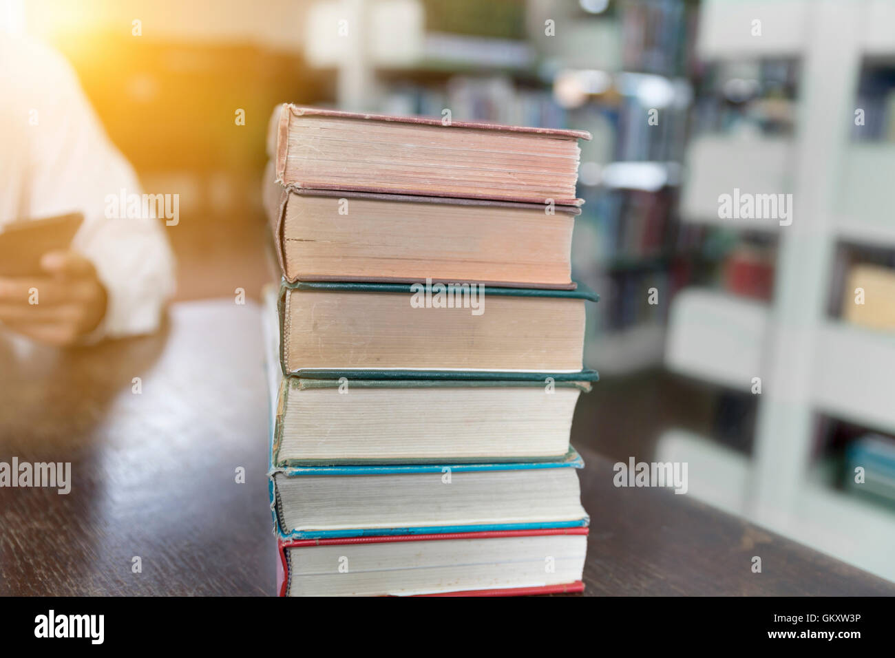 altes Buch Stack auf Holztisch mit Bibliothek Hintergrund weichzeichnen Stockfoto