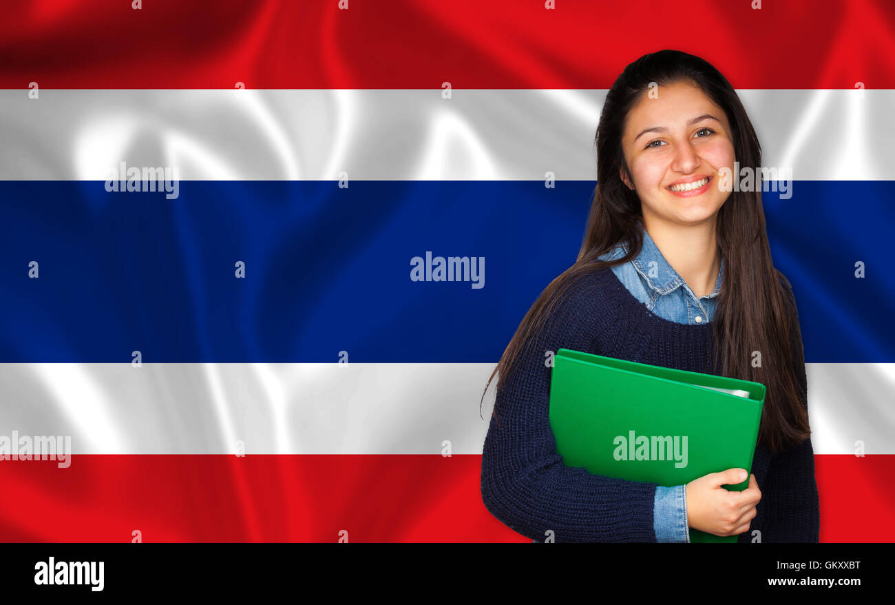 Teen Student lächelnd über thailändische Flagge. Konzept von Lehren und lernen von Fremdsprachen. Stockfoto