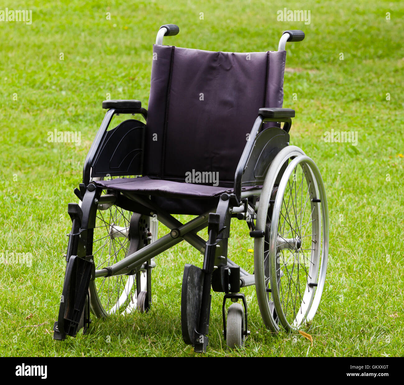 Leeren Rollstuhl auf Wiese im Park. Stockfoto