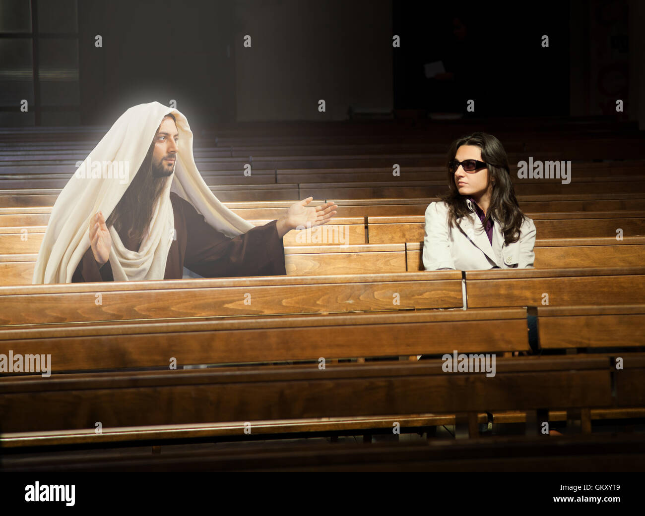 Frau in Kirche und sieht Jesus Christus beten. Stockfoto
