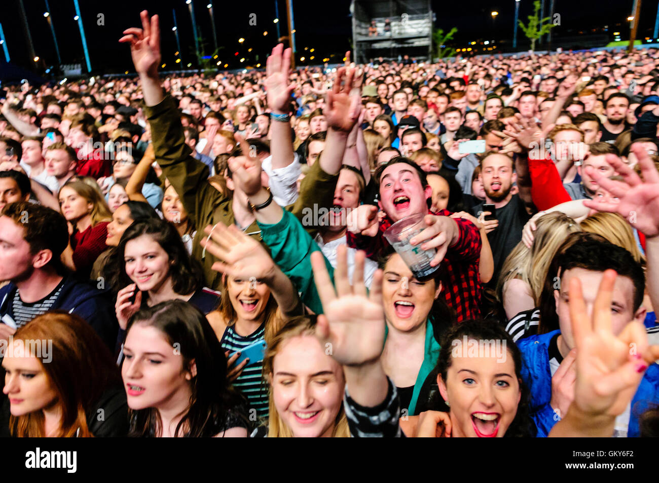 Eine Menschenmenge, späten Teenager, Mitte bis Ende der zwanziger Jahre, freuen uns auf ein Musikfestival. Einige haben Kunststoff-Gläser Alkohol Bier etc.. Stockfoto