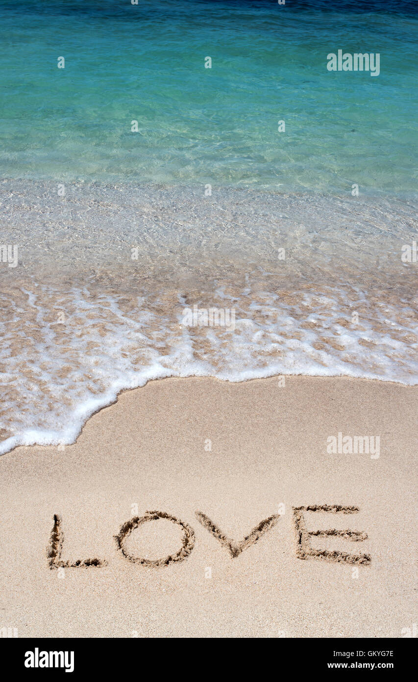 Romantischen Strandurlaub mit dem Wort Liebe handschriftlich in den goldenen Strandsand Stockfoto