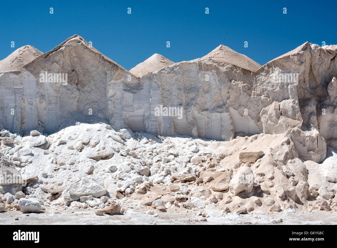 Berge von Salz oder salzhaltigen ausgetrocknet durch Verdampfung von der heißen Sonne auf ein Salz landwirtschaftlicher Haupterwerbsbetrieb unter einem klaren sonnigen blauen Himmel Stockfoto