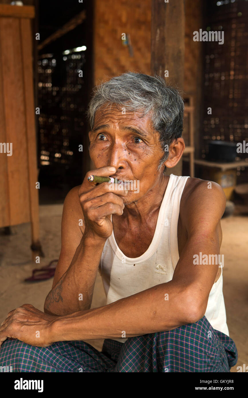 Ein birmanischen Mann Rauchen in seinem Haus in Minnathu Dorf in der Nähe von Bagan, Myanmar (Burma). Der Mann raucht eine lokal gerollte Zigarre. Stockfoto