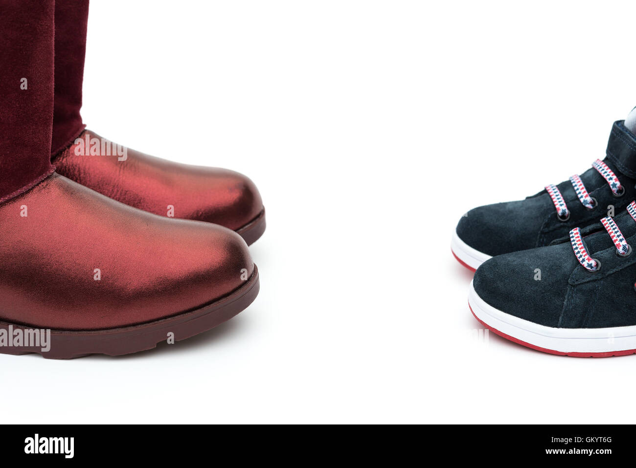 schwarze Schuhe für Sohn und roten für Mama auf weiß als Abstammung Konzept Stockfoto