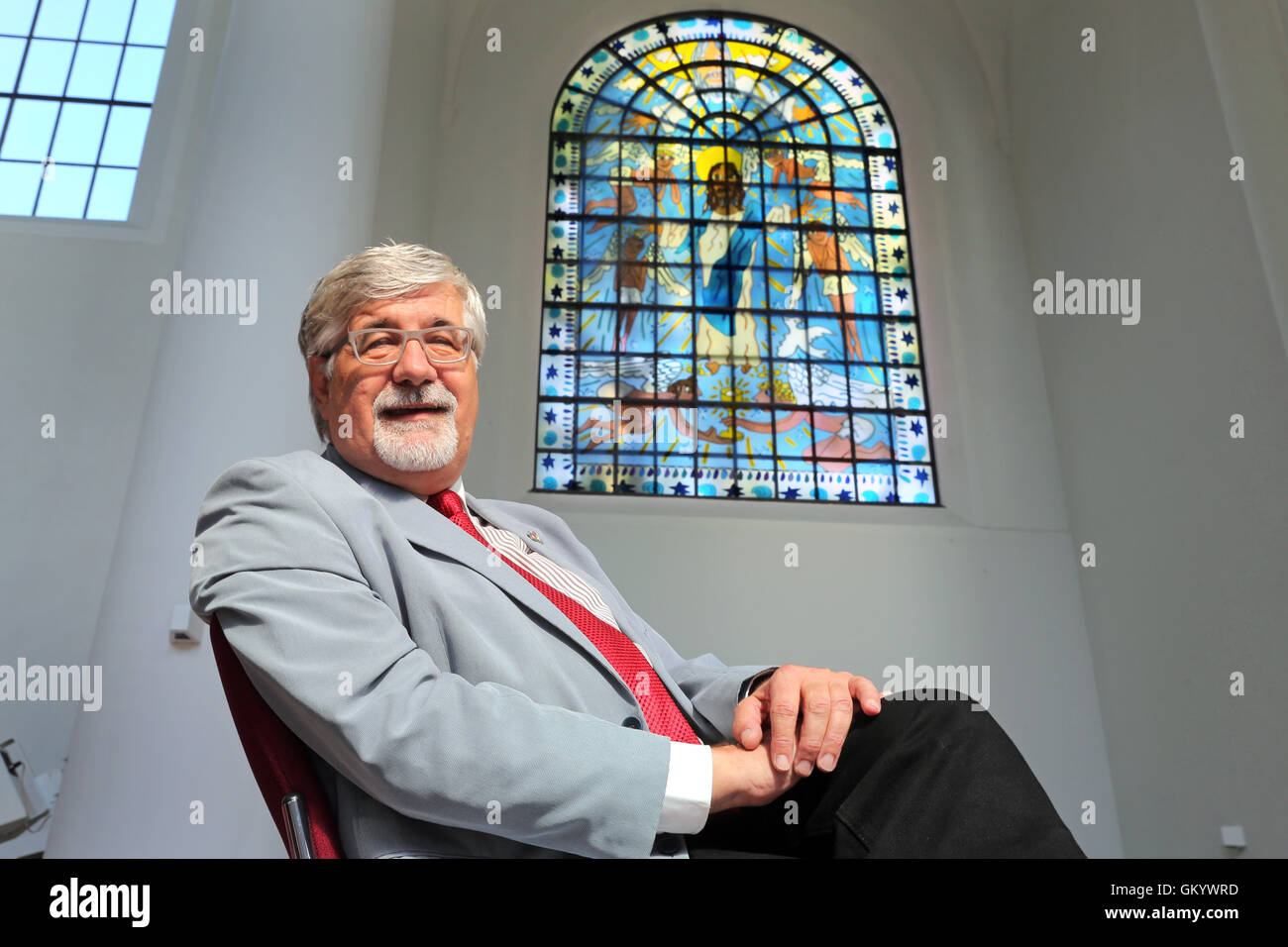 Eines der zwei Kirchenfenster von der New Yorker Pop-Künstler JAMES RIZZI (* 1950 +2011) in der Kirche Kreuzeskirche in Essen, Deutschland. Pfarrer Steffen Hunder sitzt unter einem neuen Fenster in seiner Kirche. Stockfoto