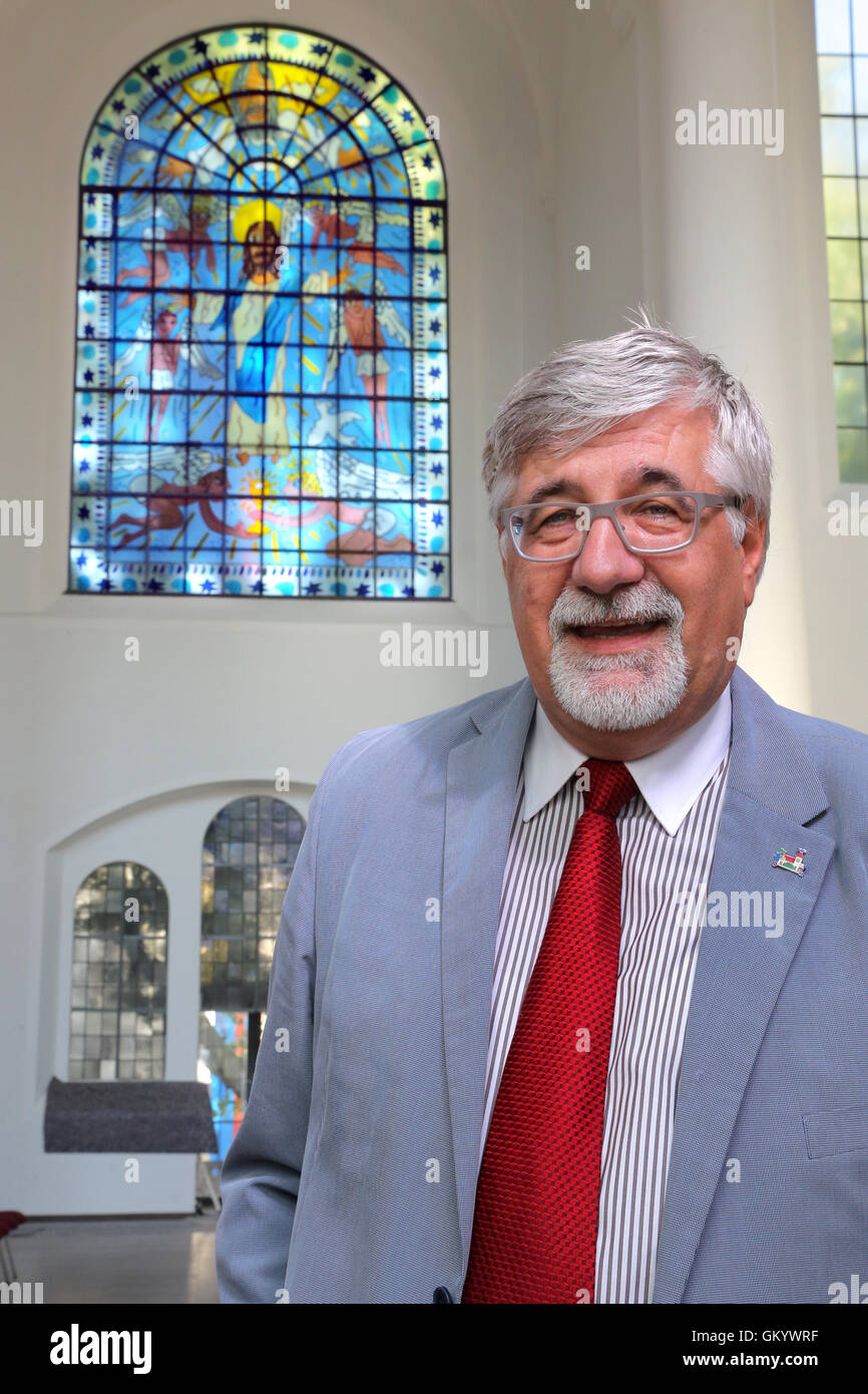 Eines der zwei Kirchenfenster von der New Yorker Pop-Künstler JAMES RIZZI  (* 1950 +2011) in der Kirche Kreuzeskirche in Essen, Deutschland. Pfarrer Steffen  Hunder steht unter einem neuen Fenster in seiner Kirche