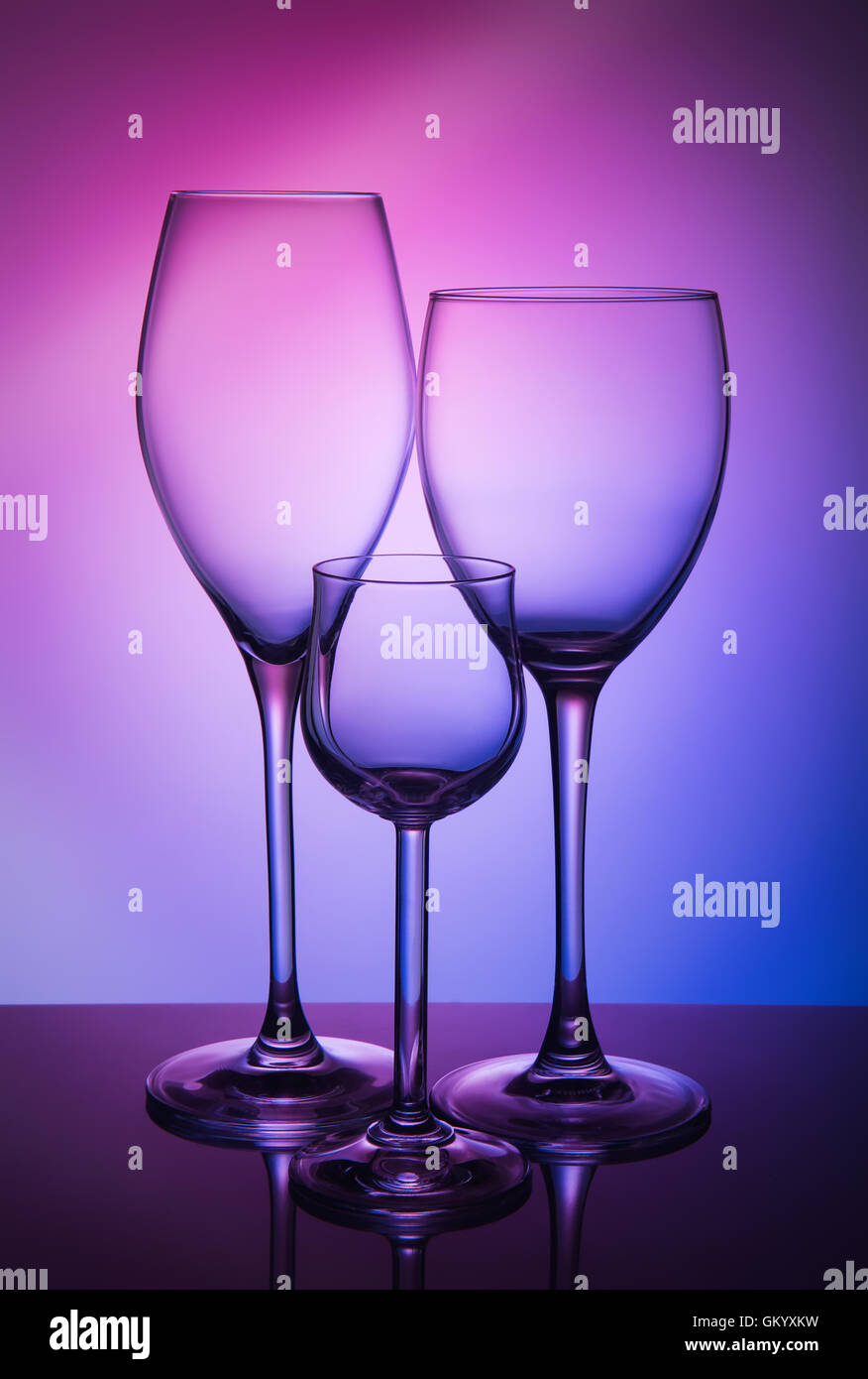 Drei verschiedene Weinglas auf farbigem Hintergrund Stockfoto