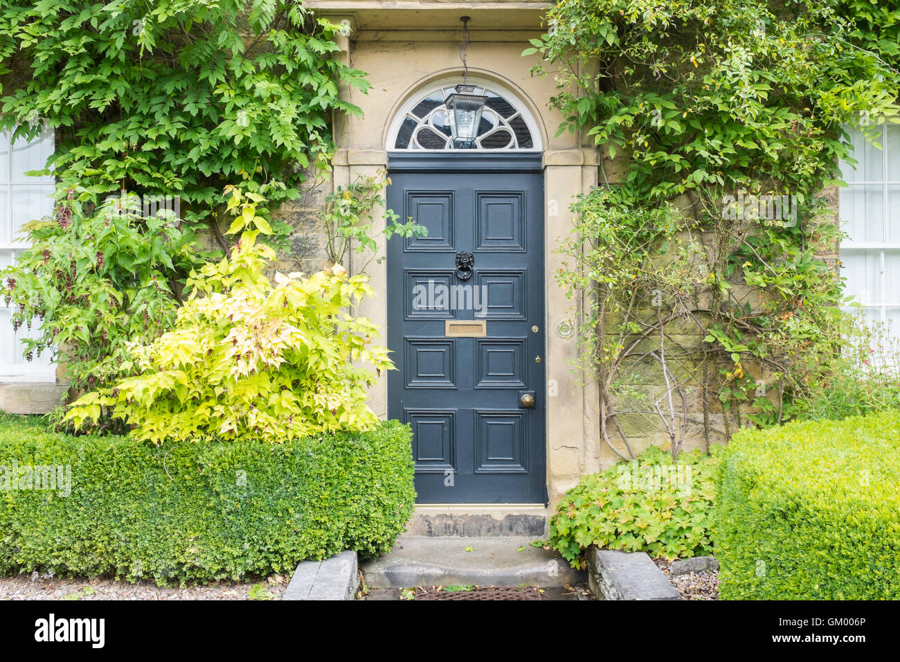 Intelligente Steinhaus mit dekorativen Box Hecke in den Peak District Ashford im Wasser Stockfoto