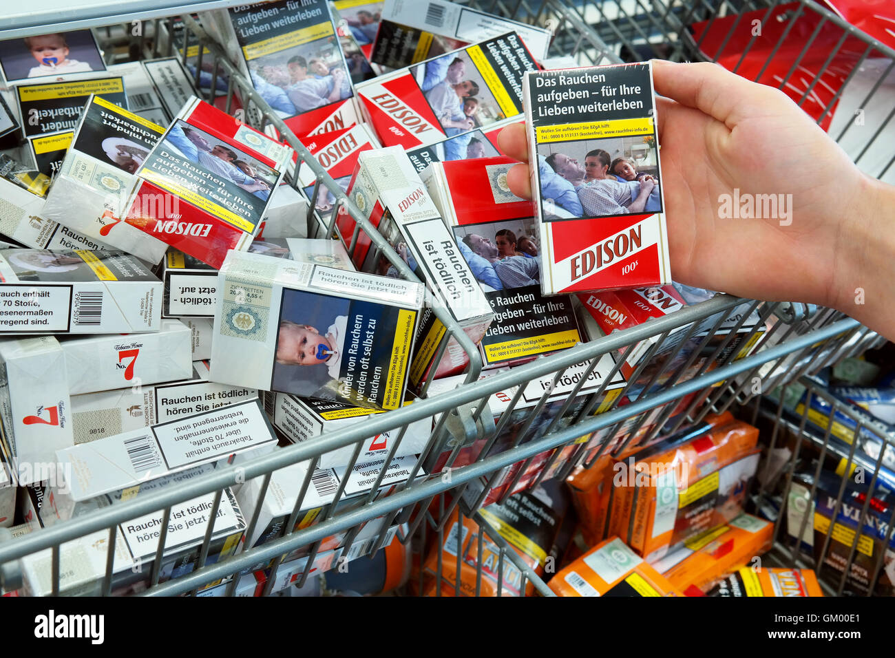 Zigaretten in einem Aldi-Supermarkt mit Bildern auf Zigarettenschachteln, die Gefahren des Rauchens zu illustrieren Stockfoto