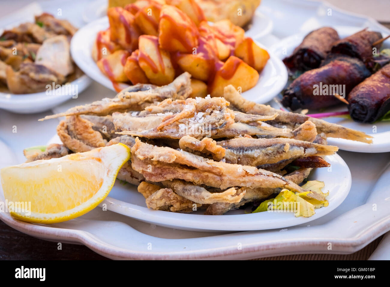 Eine Auswahl an mallorquinischen Tapas-Gerichten, vorne im Bild einschließlich Boquerones (gebratene kleine Fische) Stockfoto