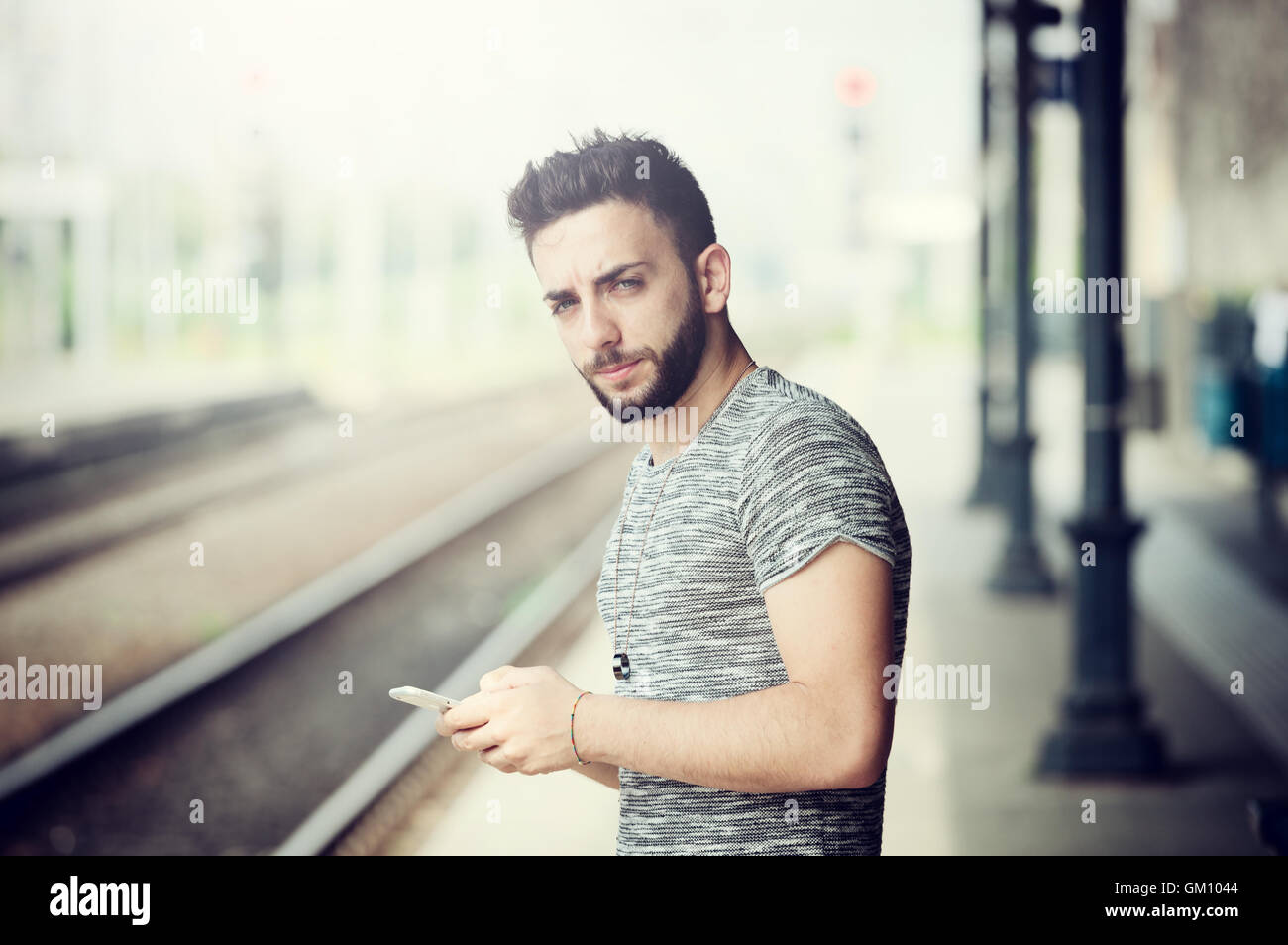 Junger Mann mit Smartphone am Bahnhof. Stockfoto