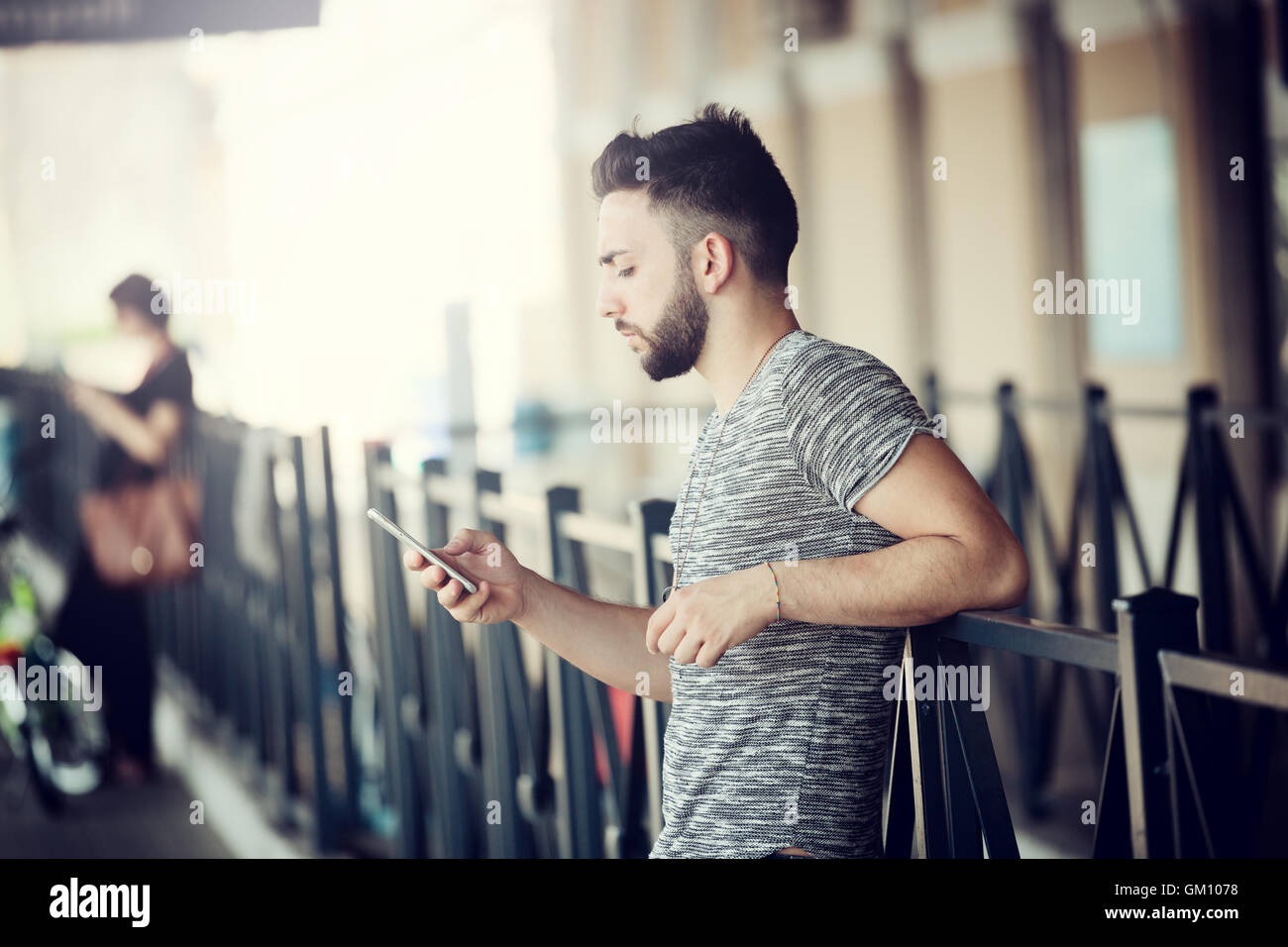 Junger Mann mit Smartphone am Bahnhof. Stockfoto