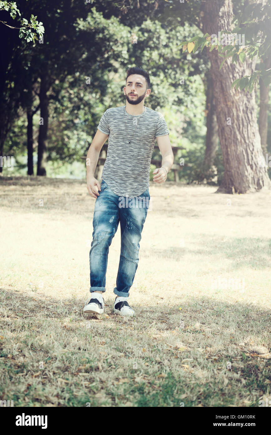 Junger Mann im Park an einem sonnigen Tag, den ganzen Körper. Stockfoto