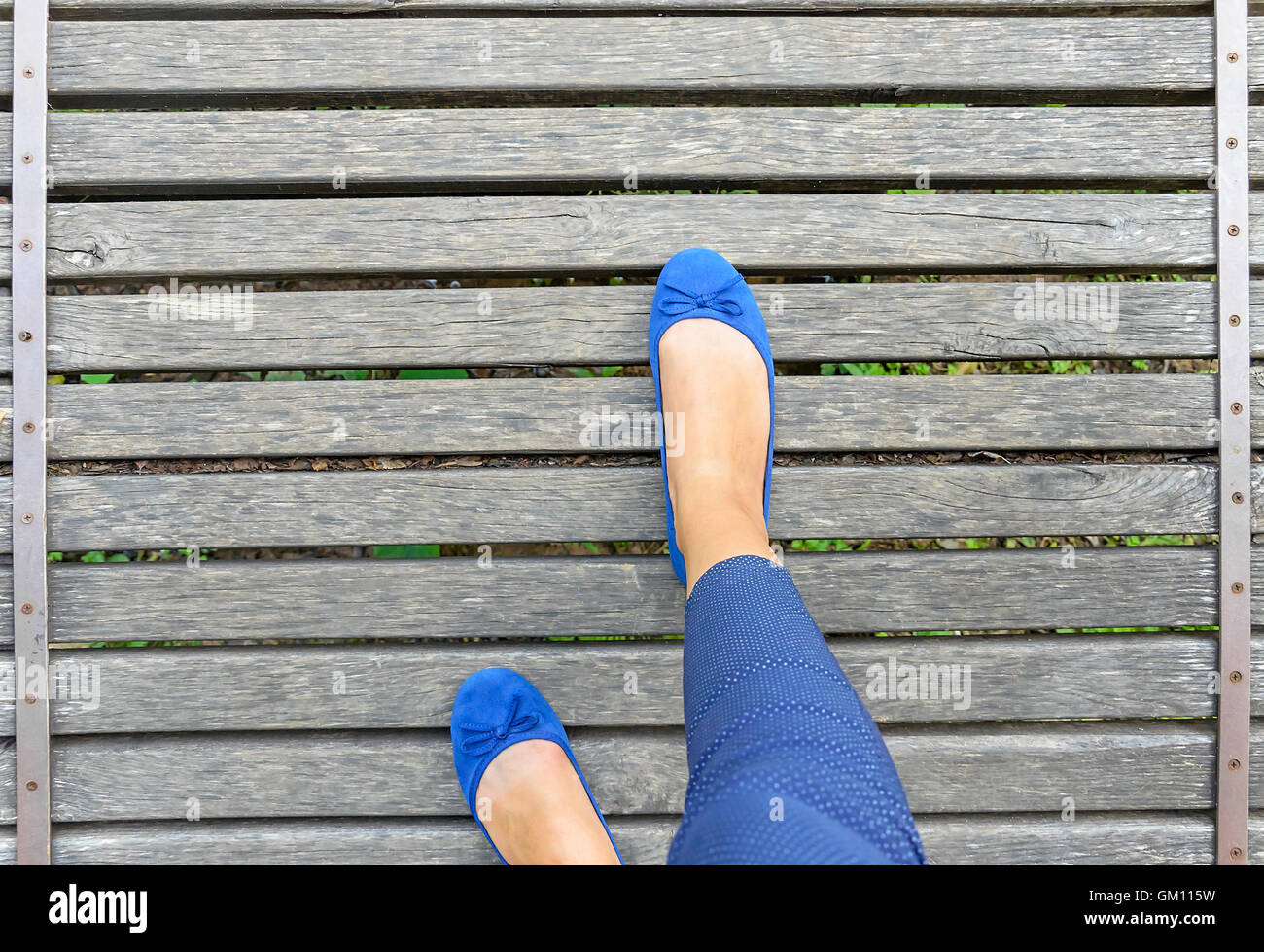 Füße in Schuhen auf einer Holzbrücke. Close-up. Ansicht von oben. Stockfoto
