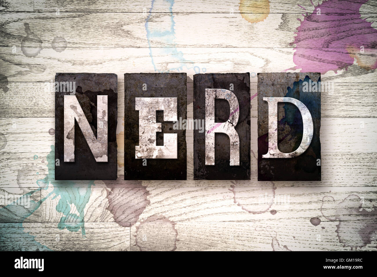 Das Wort "NERD" geschrieben in Vintage schmutzig Metall Buchdruck Typ auf einem weiß getünchten hölzernen Hintergrund mit Tinte und Farbe Flecken. Stockfoto