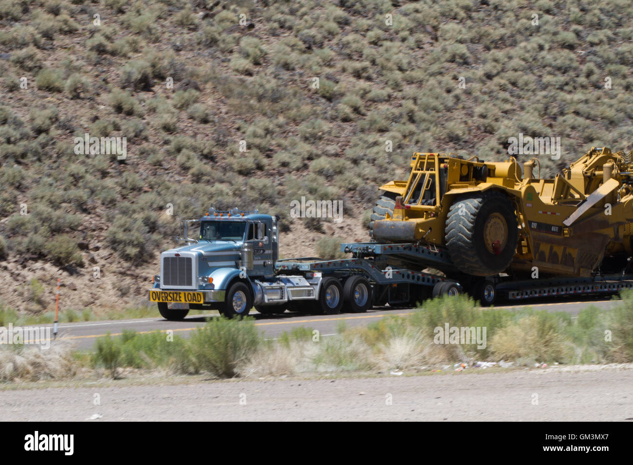 Große Lkw schleppen eine Erdbewegung Maschine. USA Stockfoto