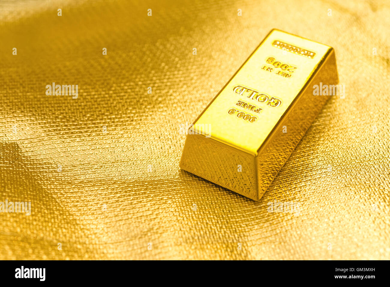 Stück Goldbarren auf goldenem Hintergrund Stockfoto
