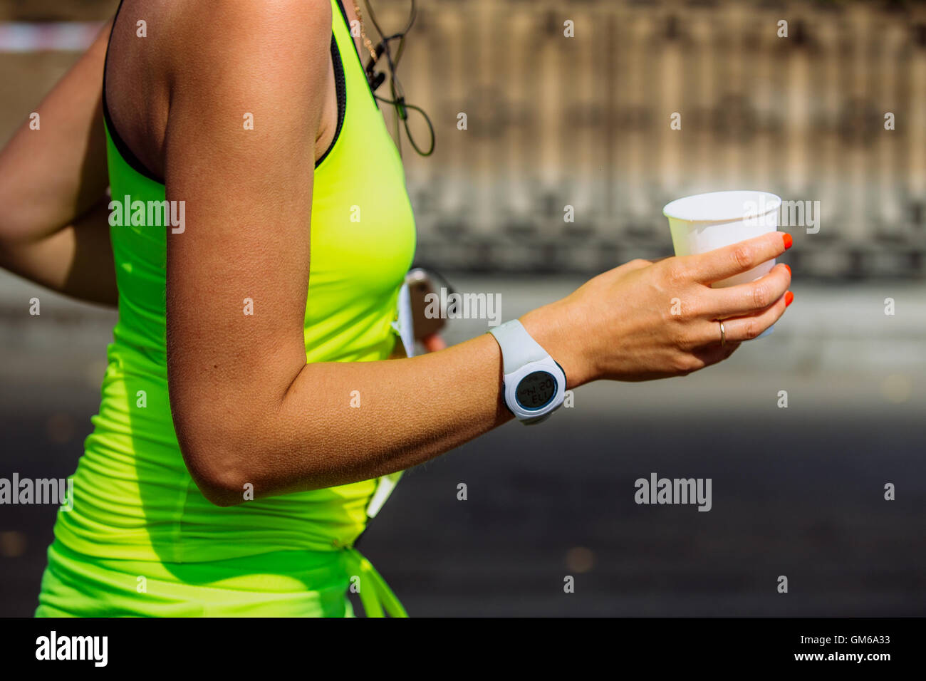 Closeup Mädchen Läufer Hand hält ein Glas Wasser nach waterpoint Stockfoto