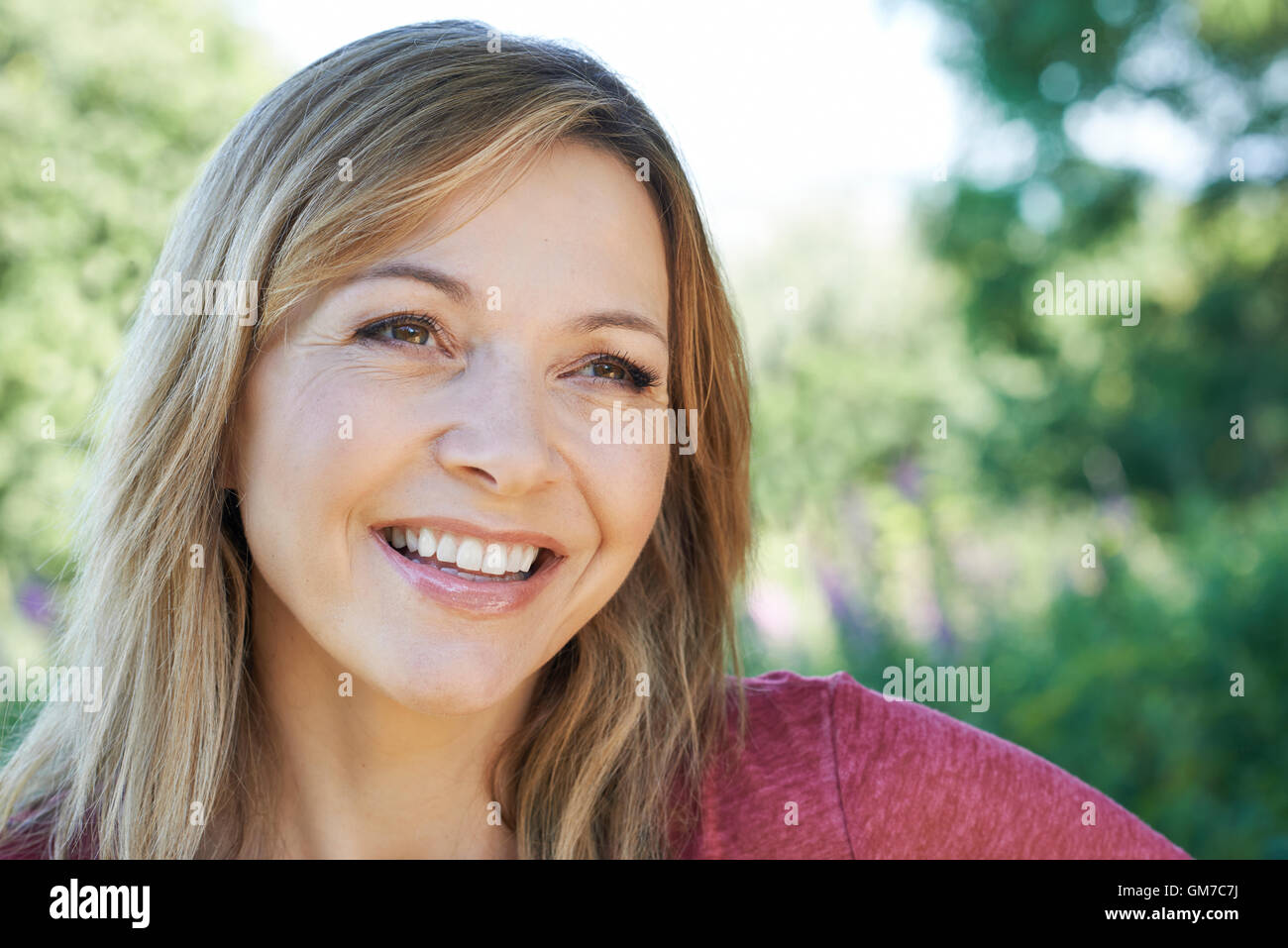 Im freien Kopf und Schultern Portrait Of Smiling Reife Frau Stockfoto